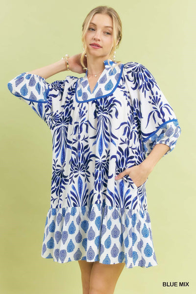 Woman wearing a blue and white patterned dress on a light green background